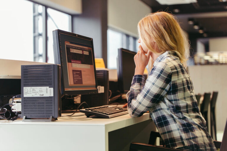 Garota no computador aprendendo como centralizar texto com CSS utilizando o Text Align